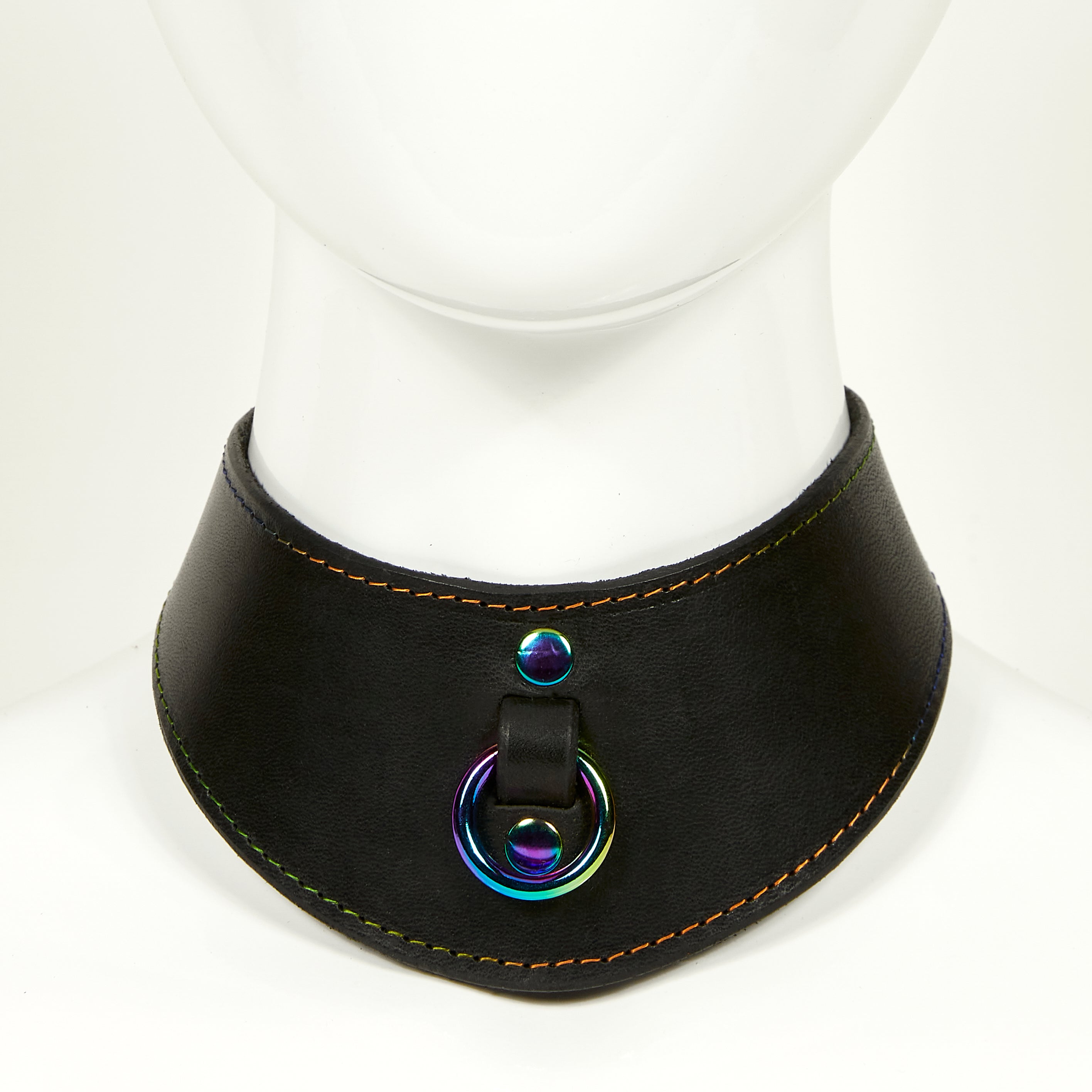 NAOMI COLLAR front view of wide, curved style collar in black leather with rainbow stitched edges, rainbow o-ring suspended from a strap tucked into collar, riveted with rainbow hardware