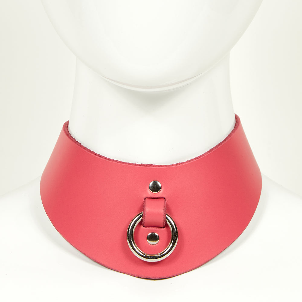 
                  
                    NAOMI COLLAR front view of wide, curved style collar in bright pink leather with plain edges, silver o-ring suspended from a strap tucked into collar, riveted with silver hardware
                  
                
