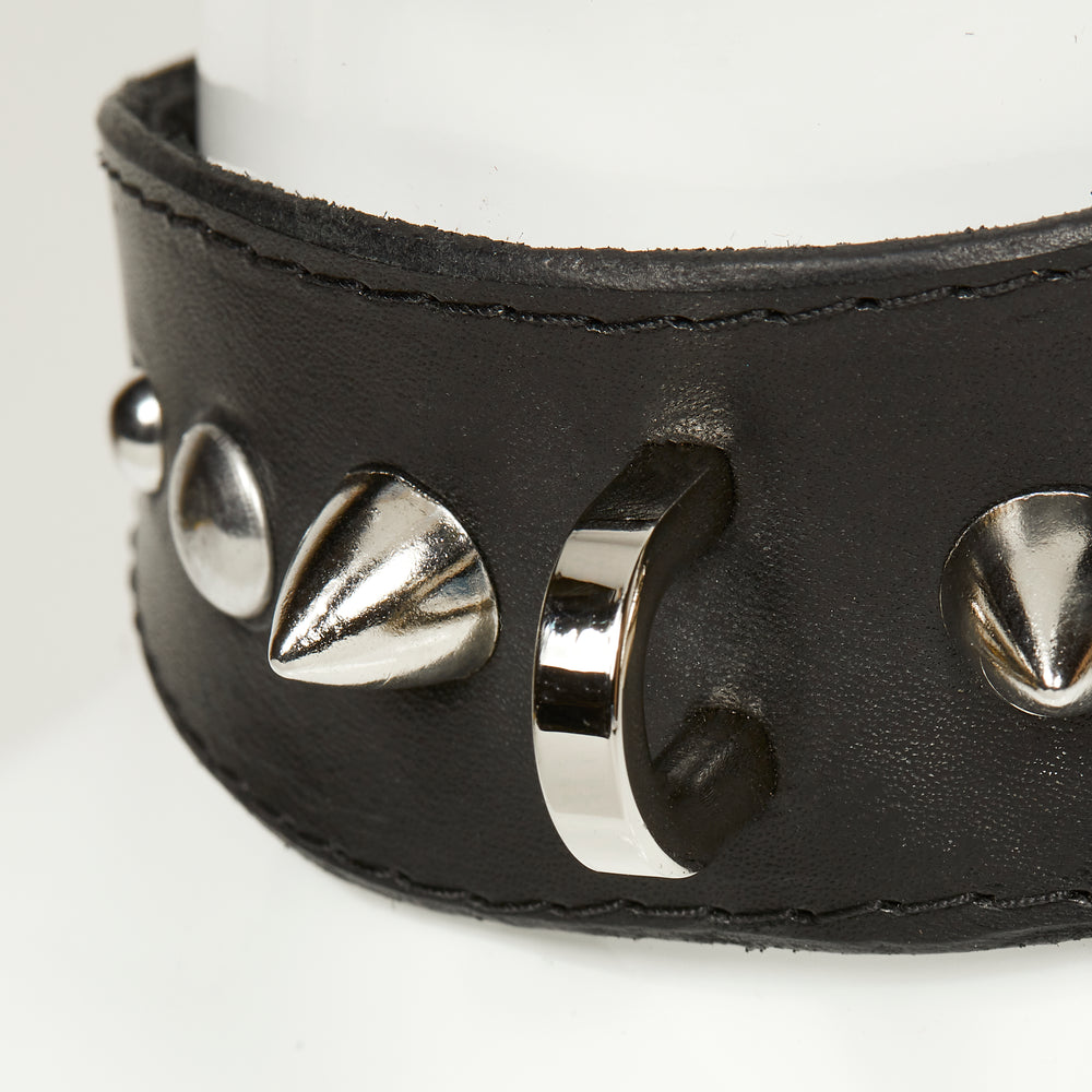 
                  
                    NIKKI COLLAR 3/4 real close view of object in black leather with black stitched edges, showing close profile of gradation of silver rivets, spikes, and d-ring hardware
                  
                
