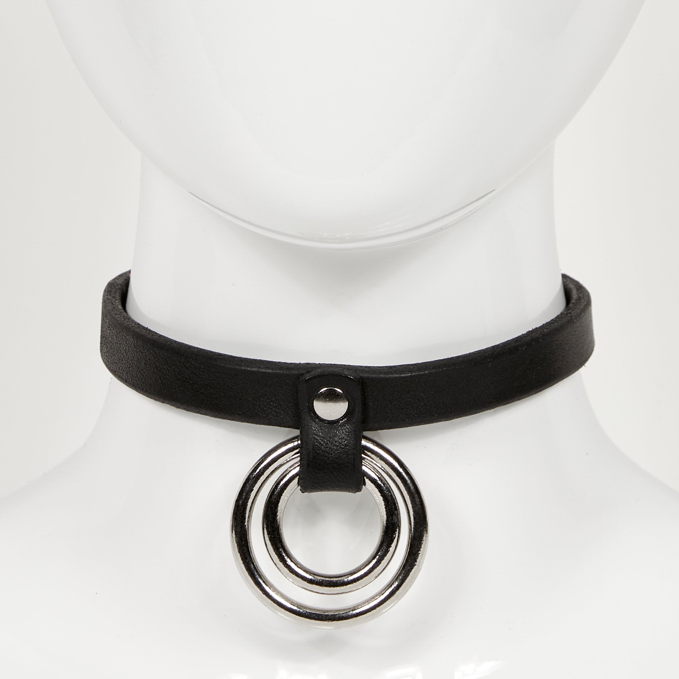 front view of slim leather choker on mannequin neck, with two concentric o-rings hanging from a strap rivited to main jewelry ERIN