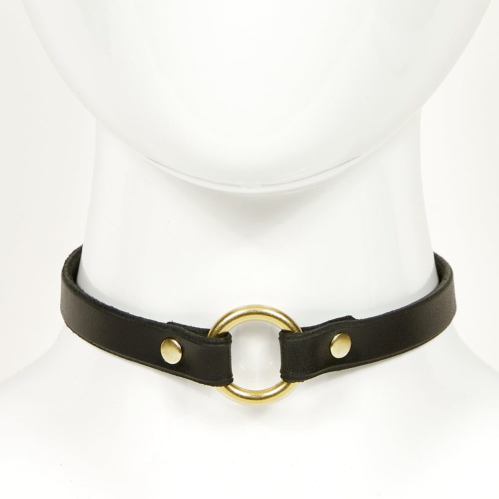 
                  
                    O-RING CHOKER SLIM front view of a black leather necklace with gold circular ring, attached with gold rivets
                  
                